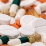 Close-up of various pills and capsules in different colors and sizes, ideal for healthcare-related content.