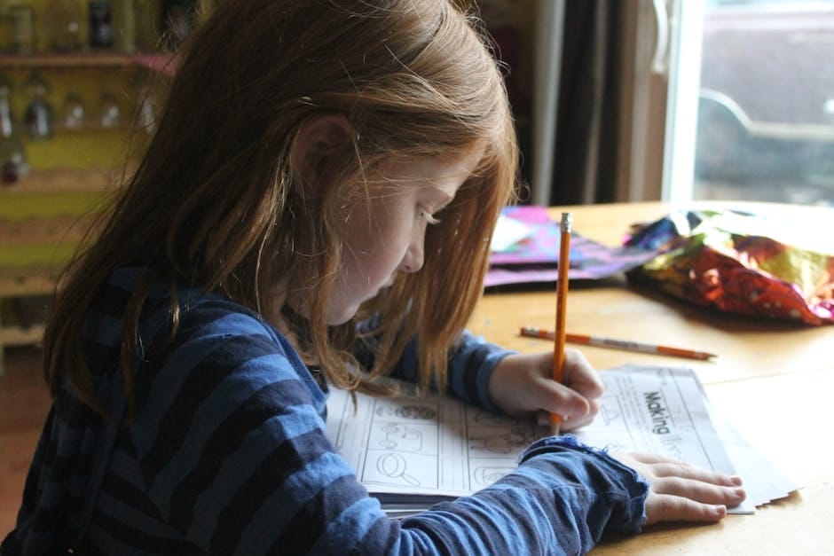 Young girl focused on homework at kitchen table with natural light.