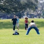 Group of kids enjoying a soccer game on a sunny day in the park.