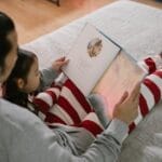 Father and daughter sharing a cozy bedtime story in a warm, home setting.