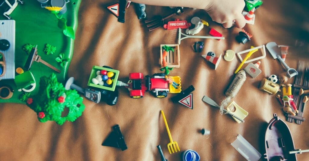 Children's hands playing with colorful toys on a mat, sparking creativity and fun.