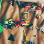 Children's hands playing with colorful toys on a mat, sparking creativity and fun.