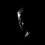 Captivating silhouette of a child in dramatic black and white lighting.