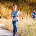 Children joyfully running in a park during a cheerful outdoor race event.