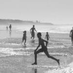 Black and white photo of children enjoying a carefree day at Agadir Beach, Morocco.