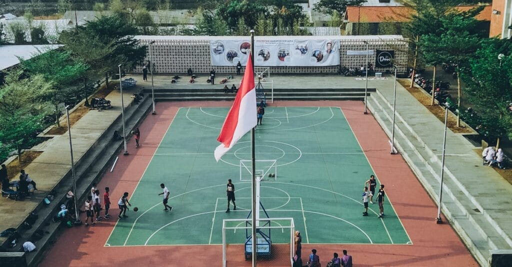 Aerial view of students playing basketball on an outdoor court in Jawa Tengah, Indonesia.