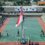 Aerial view of students playing basketball on an outdoor court in Jawa Tengah, Indonesia.