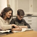 Brother and sister studying together at home, focusing on homework and learning.