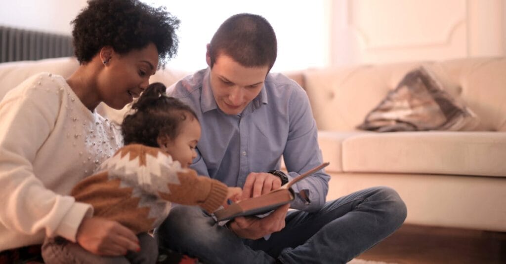 A diverse family enjoying storytime together, fostering love and learning indoors.