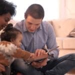 A diverse family enjoying storytime together, fostering love and learning indoors.