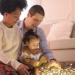 A family enjoys quality bonding time with string lights in their cozy living room.