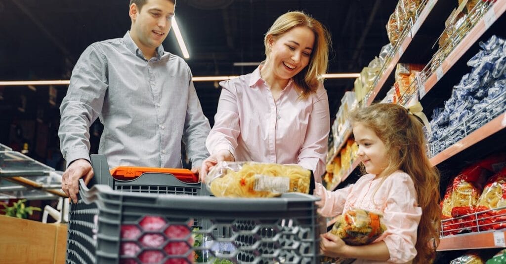 A joyful family of three shopping together in a supermarket, creating a memorable experience.