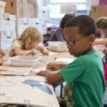 Group of children focused on educational activities in a classroom setting.