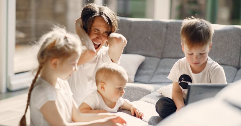 Woman going mad while sitting with little kids playing together on sofa in well lit room