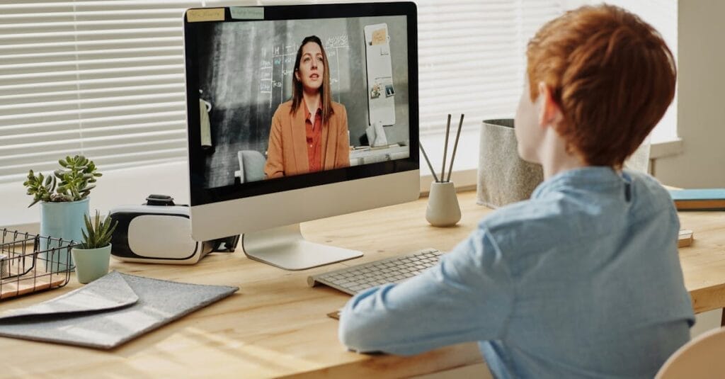 Child attending an online class at home via computer, enhancing remote education.