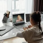 Young girl participating in an online learning session from home during the day.