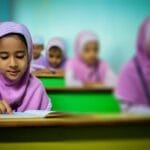 Group of young students in traditional hijabs focusing on their studies in a classroom.