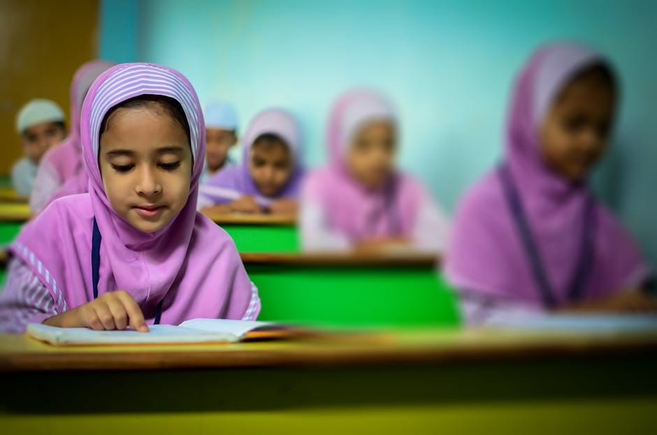 Group of young students in traditional hijabs focusing on their studies in a classroom.