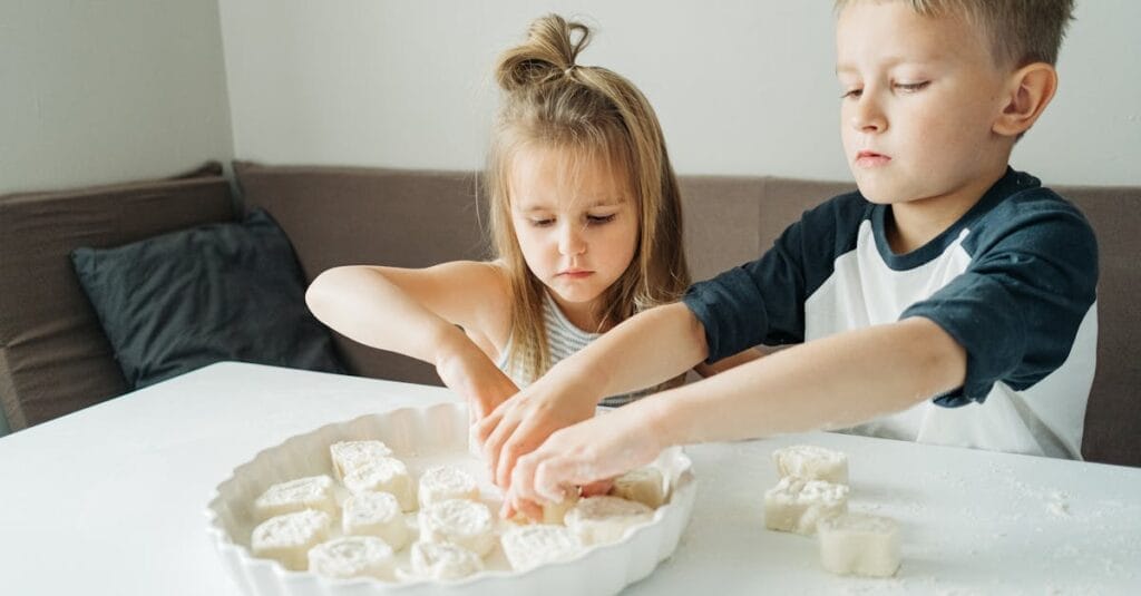 Children enjoying a fun bonding moment as they bake cookies at home.