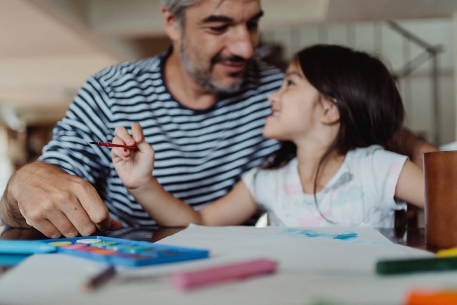 Father and daughter bonding through painting at a desk, creating art together indoors.