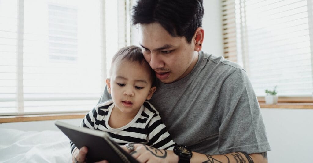 Father and son enjoying quality time using a tablet at home. Capturing a moment of connection.