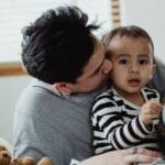 A touching moment of a father and son bonding indoors, exploring a globe together.