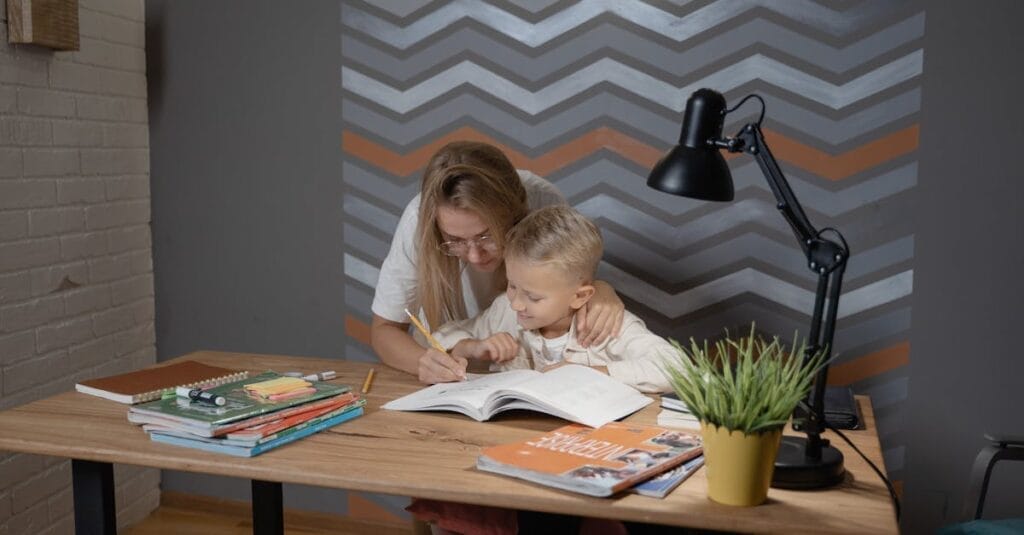 A mother assists her son with homework at a desk, fostering a learning environment.