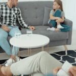 Family therapy session featuring parents and child with therapist in a cozy office setting.