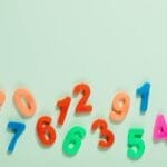 Bright plastic numbers on a mint green background for learning and education.