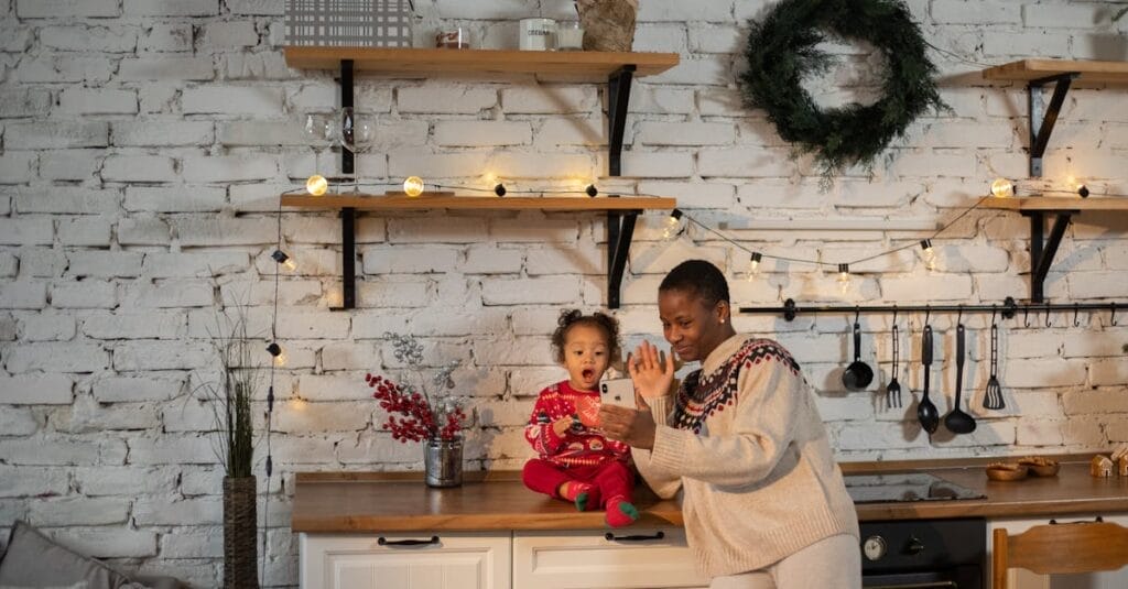 A happy mother and child enjoy a video call in a festively decorated kitchen, capturing a joyful moment.