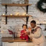 A happy mother and child enjoy a video call in a festively decorated kitchen, capturing a joyful moment.