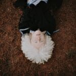 Portrait of an albino child lying on an earthy, natural background, showcasing unique beauty.