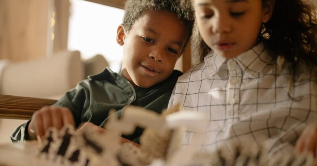 Warm moment of a brother and sister reading a book together at home, capturing innocence and togetherness.