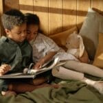 Two children reading together in a cozy room, capturing sibling love and togetherness.