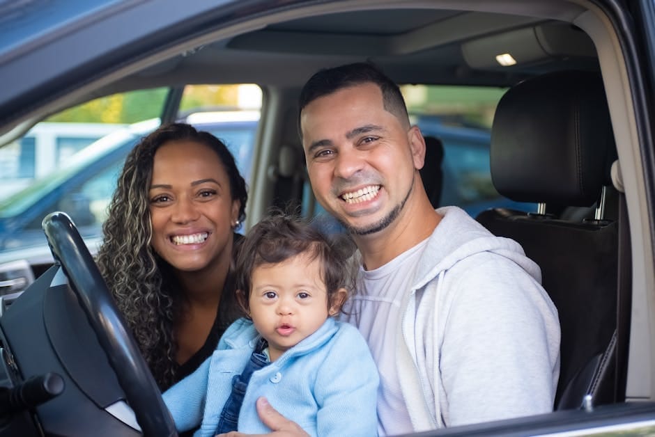 Family of three smiling in a car, showcasing joy and togetherness.