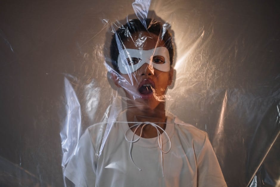 A child in a white mask stands behind translucent plastic, creating a mysterious atmosphere.