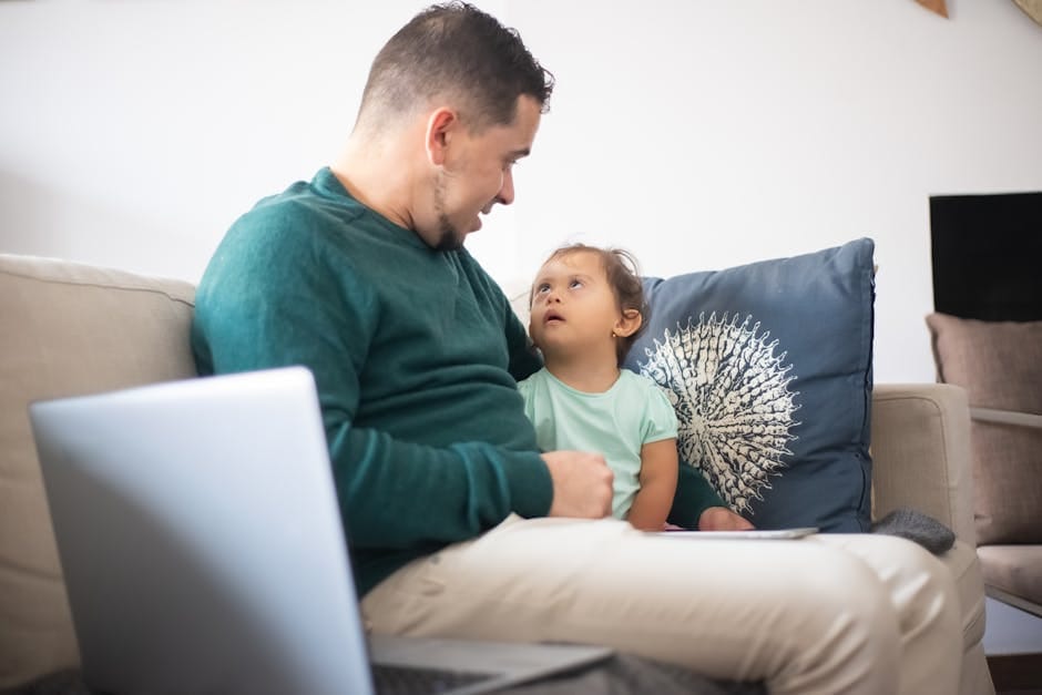 A father spending quality time with his daughter on a comfortable sofa at home.