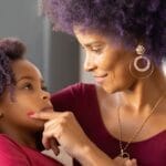 A mother and daughter share a tender moment full of love and connection indoors.