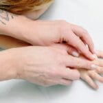 Close-up of a child receiving a comforting hand massage for relaxation and care.