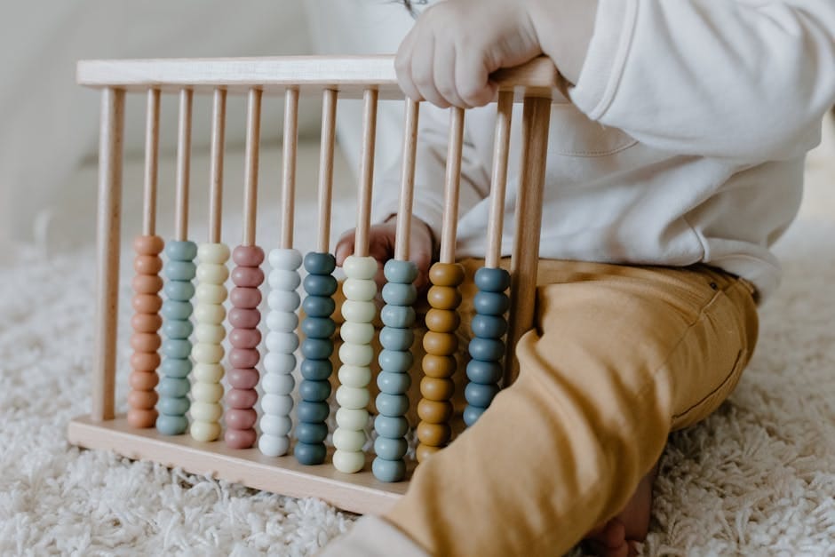 A young child engaging in learning with a wooden abacus on a carpet, emphasizing early education.