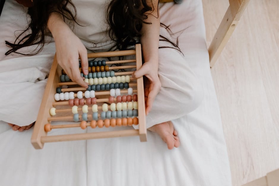 A child using a colorful abacus to learn math in a cozy indoor setting.