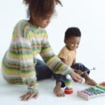 Mother and child enjoying playtime with colorful educational toys in a bright setting.