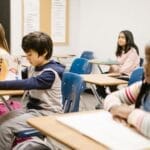 Children focused on a lesson in a diverse classroom environment fostering inclusivity.