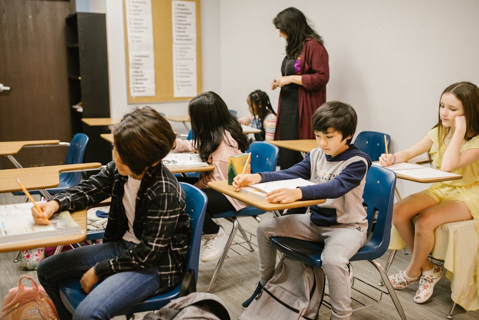 Engaged students in a classroom setting with attentive teacher guidance.