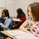 Diverse group of children studying in a classroom setting.