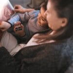 Grandmother and child enjoying a cozy afternoon reading together indoors.