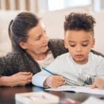 A grandmother lovingly assists her grandson in a cozy home setting.