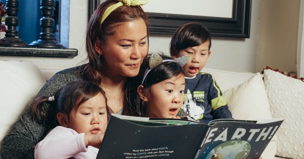 A joyful family bonding over a book at home, highlighting motherhood and togetherness.