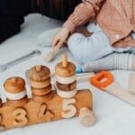 Young child playing with educational wooden toys indoors. Promotes creativity and learning.