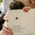 A joyful family reading a children's storybook together indoors, showcasing affection and warmth.